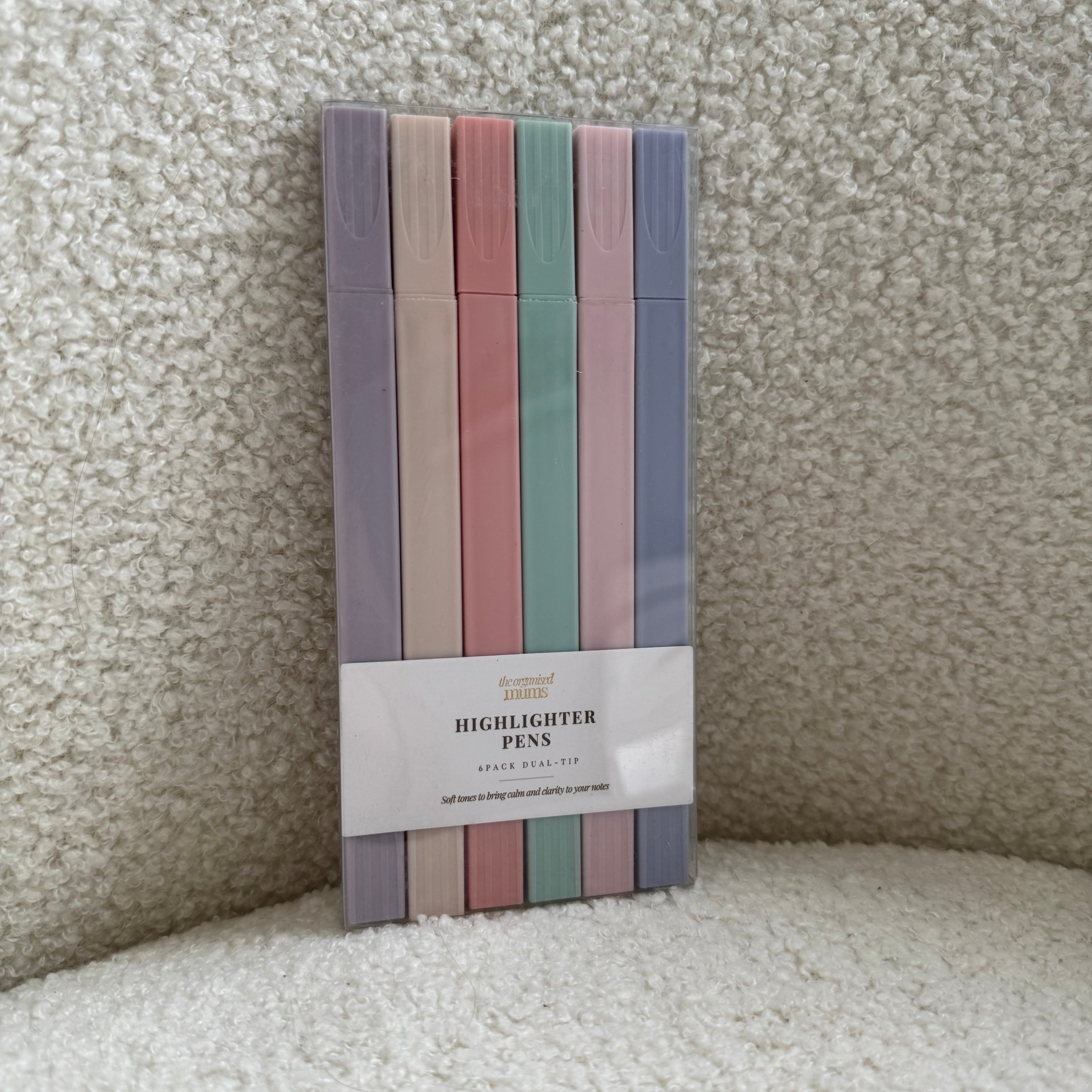 Pack of colorful pastel highlighters on a textured surface